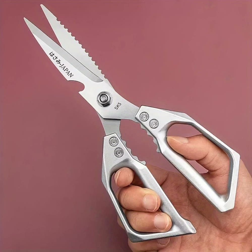 A hand holding the shears open, showing the serrated top blade and the moulded metal handles